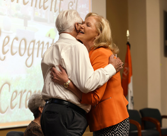 Penny Elkins and Chief Gary Collins hug at Mercer's Retirement and Recognition Ceremony